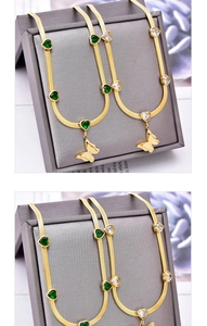 Detail of gold herringbone chains with heart crystals and a matte butterfly pendant