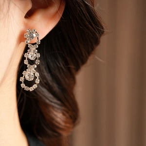 Close-up of silver long drop earrings with crystal circles on a female model