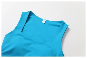 Detail of cyan athletic top featuring a square neckline and smooth breathable fabric