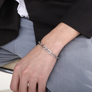 Close-up of men's stainless steel geometric chain bracelet on wrist with high polish