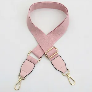 Adjustable pink canvas bag strap with gold metal hooks and light pink leather ends
