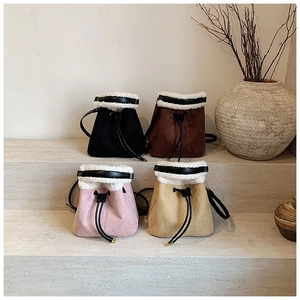 Detailed display of four faux suede bucket bags with fuzzy faux fur trim and drawstring