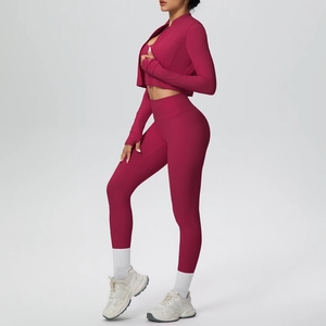 Dettaglio della giacca sportiva color bacca con fori per i pollici e leggings yoga a vita alta