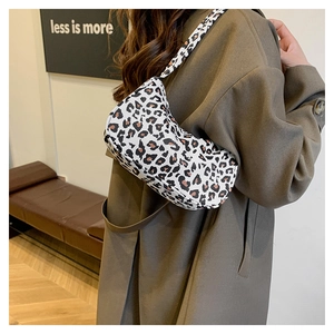 Détail du sac sous le bras à motif léopard en forme de lune porté avec un manteau marron