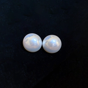 Macro shot of white round faux pearls with high luster on black velvet background