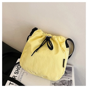 Detail of yellow nylon drawstring bucket bag on fashion magazine with soft lighting