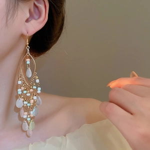 Detailansicht der langen Boho-Quastenohrringe mit bunten Perlen und matten Wassertropfen