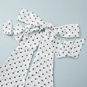 Detail of white polka dot chiffon halter neck tie with elegant bowknot and soft texture