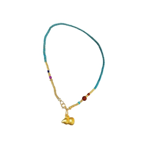 Gold-plated necklace with turquoise beads and a double gourd pendant on white background