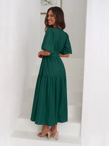 Detail of a dark green puff sleeve dress with tiered skirt on a white background