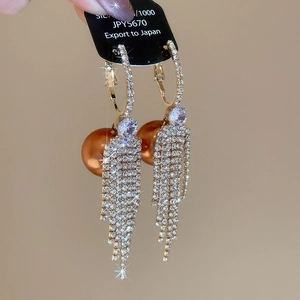 Macro shot of long fringe earrings with S925 silver base, zircons and bronze pearls