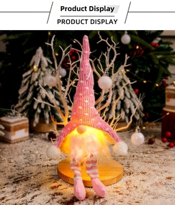 Détail d'un gnome de Noël rose en tricot avec barbe LED lumineuse sur socle bois