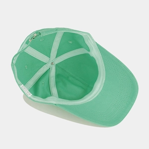 Detail of mint green cotton baseball cap inner structure with metal buckle and wash label