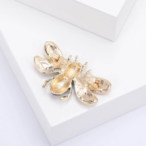 Detailed back view of golden bee brooch featuring a secure metal safety pin clasp