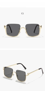 Detail of half-rim square sunglasses in gold metal with grey lenses and cutout temples