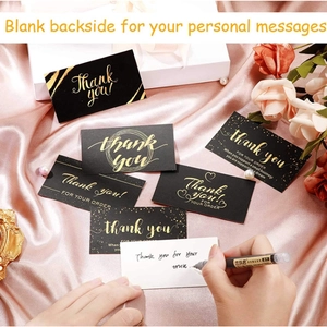 Elegant black and gold thank you cards on pink satin with white gift box and pearls