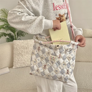 Detailed shot of quilted cotton crossbody bag with bear prints and adjustable strap