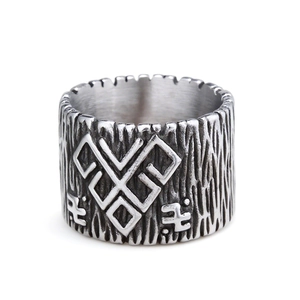 Vintage stainless steel ring with bark texture and carved rune symbols on white background