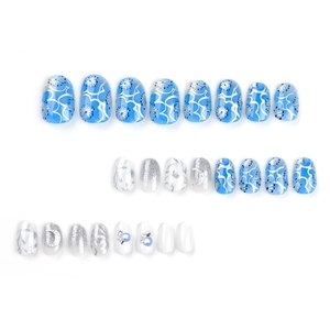 Short round fake nails set featuring blue floral designs, silver glitter, and pearl accents