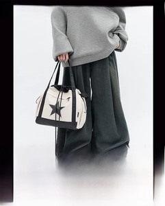 Close-up of contrast canvas shoulder bag featuring star logo and drawstring design