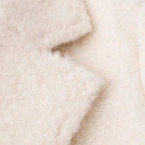Close-up macro of creamy beige wool blend textured fabric on elegant lapel