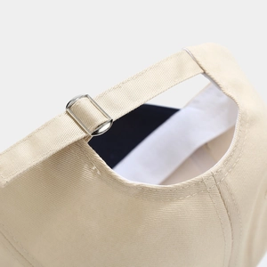 Close-up of beige cotton baseball cap back with adjustable metal buckle and stitching