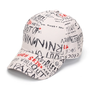 Detail view of the street style graffiti letter print on the cream baseball cap surface