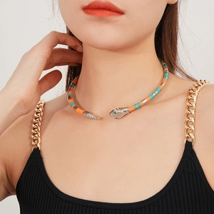 Close-up of a silver snake choker necklace with orange and turquoise segments on a model