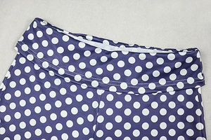 Close-up of high-waist purple pants with white polka dots showing stitching detail