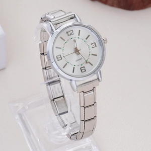 Detail of silver stainless steel watch band with quartz dial on display stand