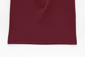 Close-up of the double-needle stitched hem on a wine red elegant long dress