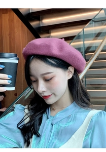 Detailed texture of purple wool beret worn by a model in a cozy cafe setting