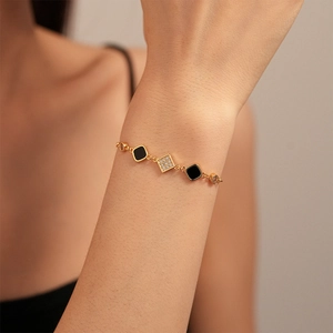 Vintage gold plated bracelet with black square zircon charms on a female wrist