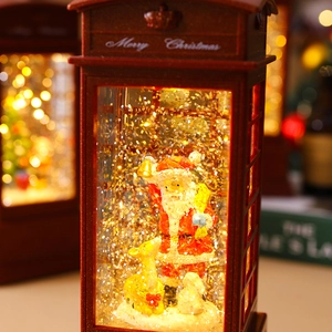 Detail of red Santa phone booth lantern with warm LED light and shimmering snow