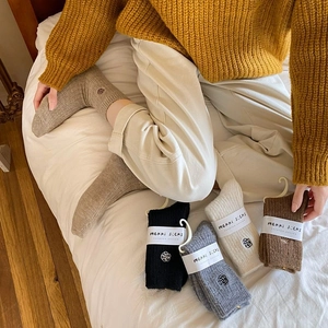 Thick winter thermal socks with flower embroidery shown in various colors on a model