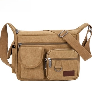 Detail showing khaki canvas crossbody bag with multiple functional zipper pockets and D-rings