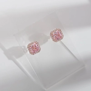 Macro shot of pink princess cut square halo stud earrings in rose gold setting