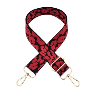 Detalle de correa jacquard de leopardo rojo y negro con cierres de langosta dorados