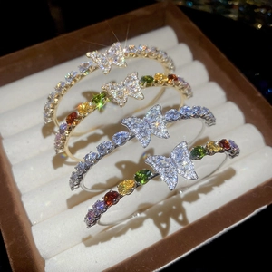 Dettaglio di bracciali a farfalla in zircone con pietre colorate in scatola portagioie