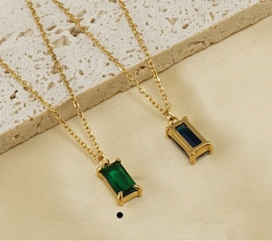 Macro view of 18K gold plated stainless steel necklaces with emerald and sapphire zircon