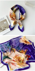 Detailed view of floral silk scarf in purple with elegant satin texture on white surface