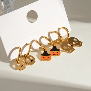 Detailed close-up of Halloween earring set with gold skulls and pumpkin charms