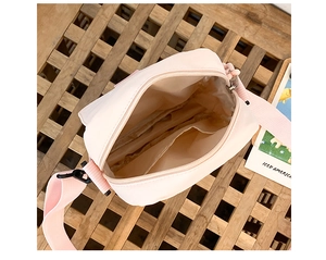Top view of pink nylon crossbody bag interior showing beige lining and zipper pocket