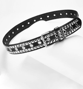 Detail of black PU leather belt with silver square studs and metal eyelets on white base