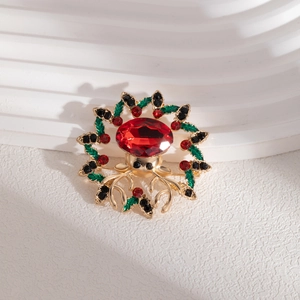 Close-up of a festive Christmas reindeer brooch with red gems and enamel holly leaves