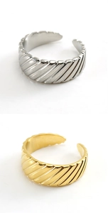 Detailed view of open rings featuring diagonal grooved texture in gold and silver finishes