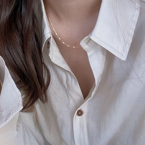 Detailed close-up of a minimalist 925 sterling silver gold-plated round sequin necklace