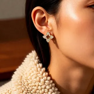 Elegant gold plated hollow flower stud earrings with sparkling cubic zirconia on model