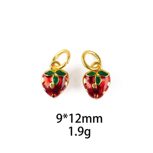 Detail of red strawberry pendants with 9x12mm size and gold enamel finish for jewelry