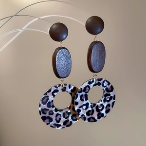 Makro-Detail von Retro-Ohrringen mit Leopardenmuster und Holzmaserung-Textur